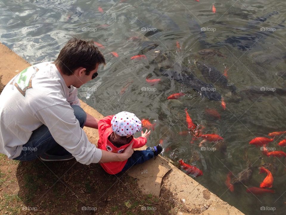 Fish in the pond with father and daughter