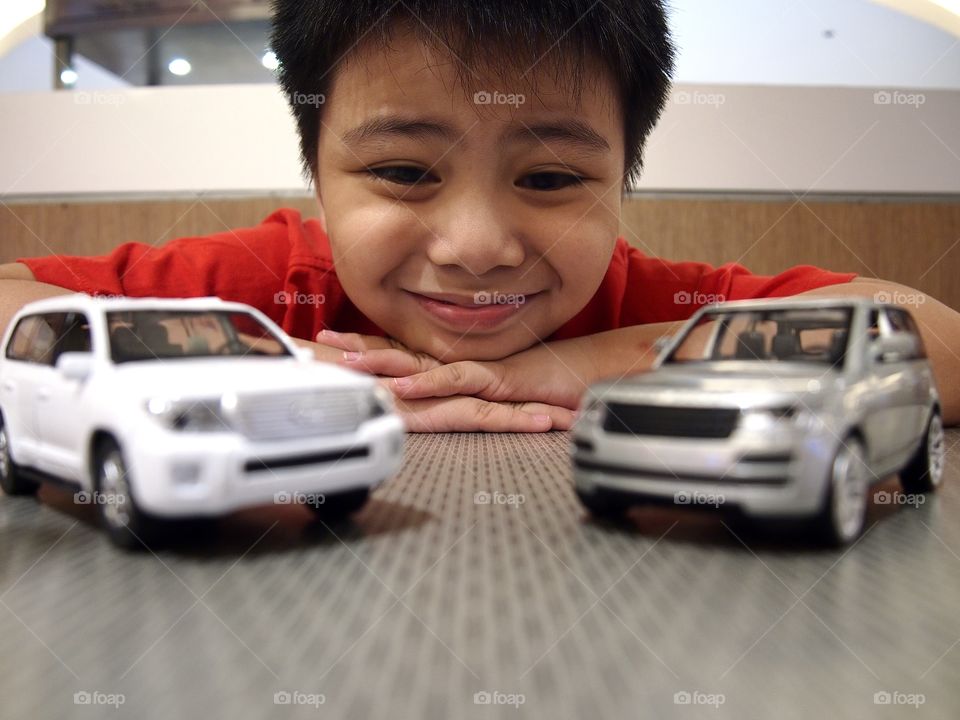 young boy playing with toy cars