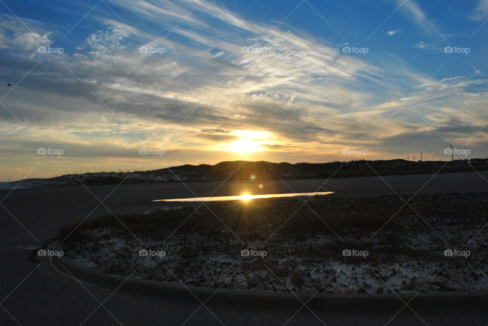 Sunset at the beach, the sun reflection in the water