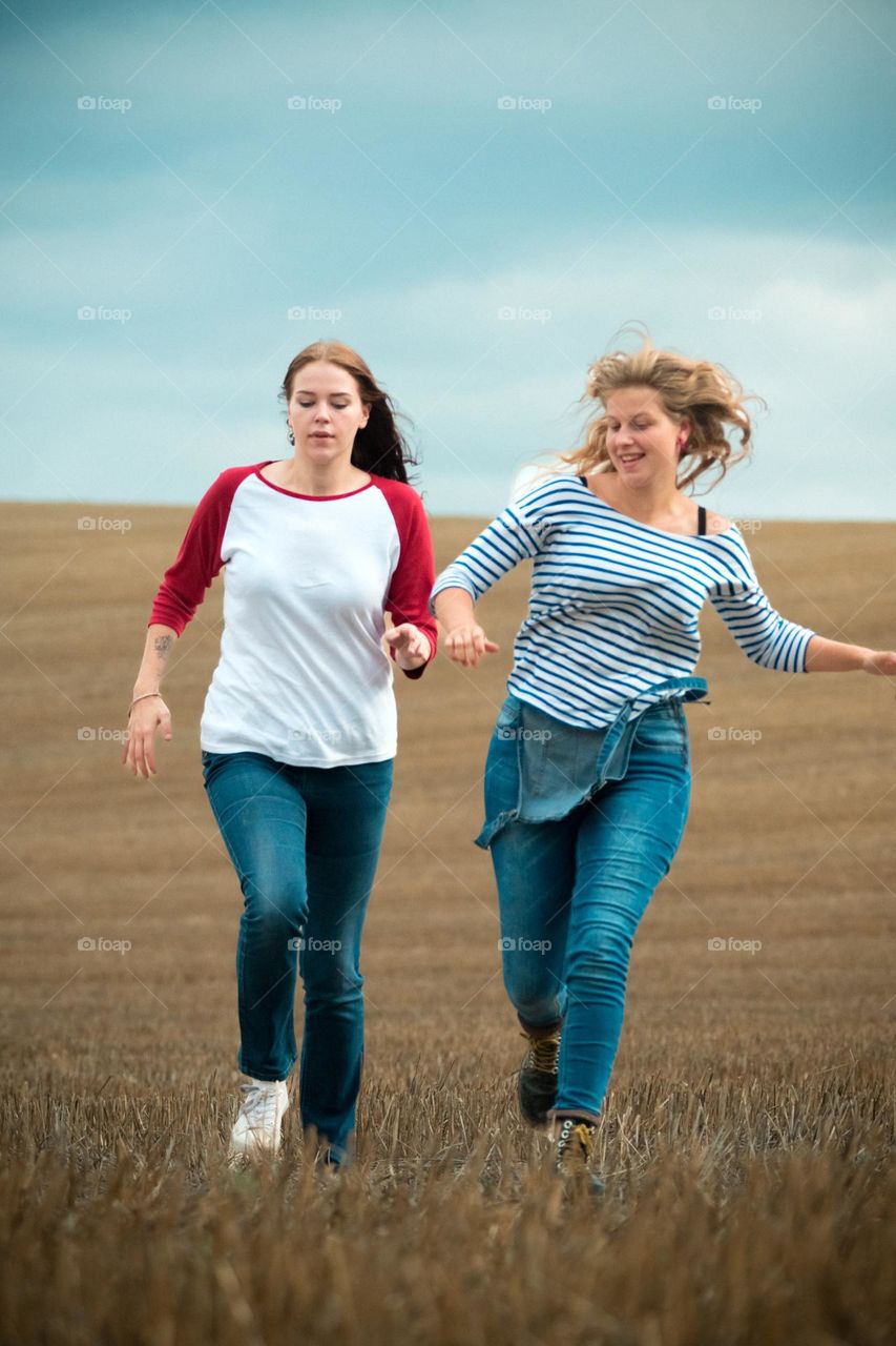 two women running together on a field