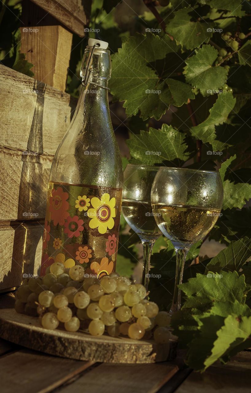 Homemade wine and grapes in the late afternoon sun