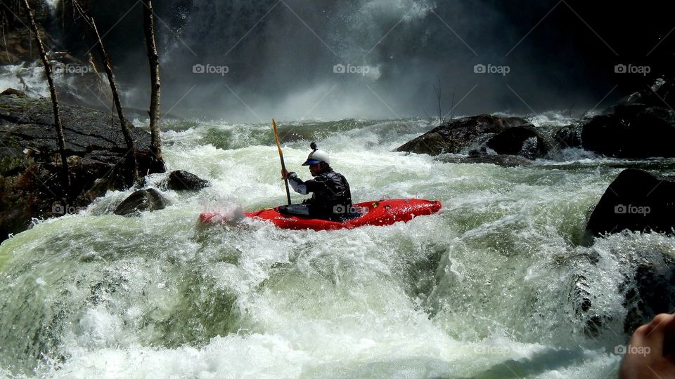 kayaker navigating roaring whitewater at base of North Carolina waterfall
