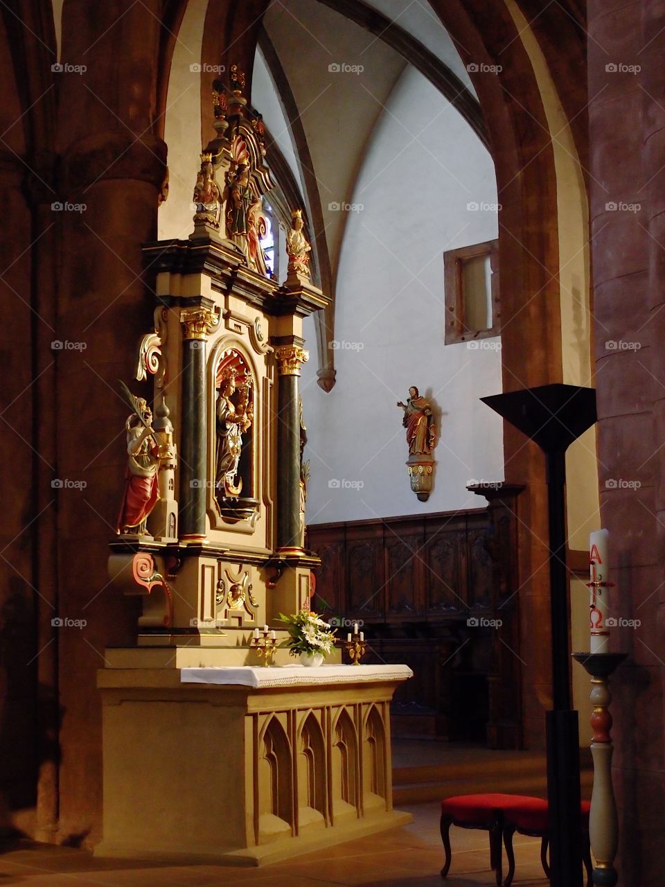 The interior of an old European church with ornate and finely detailed alters and statues. 