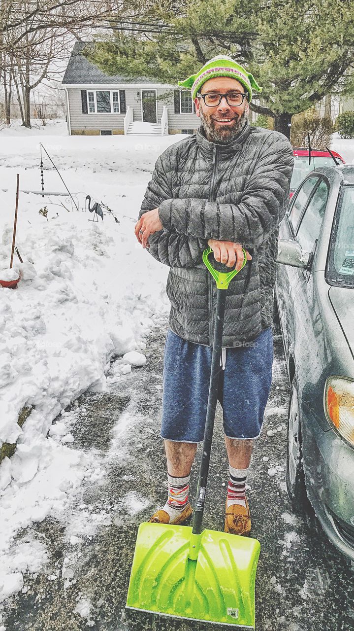 Portrait of a mature man with shovel in hand during winter