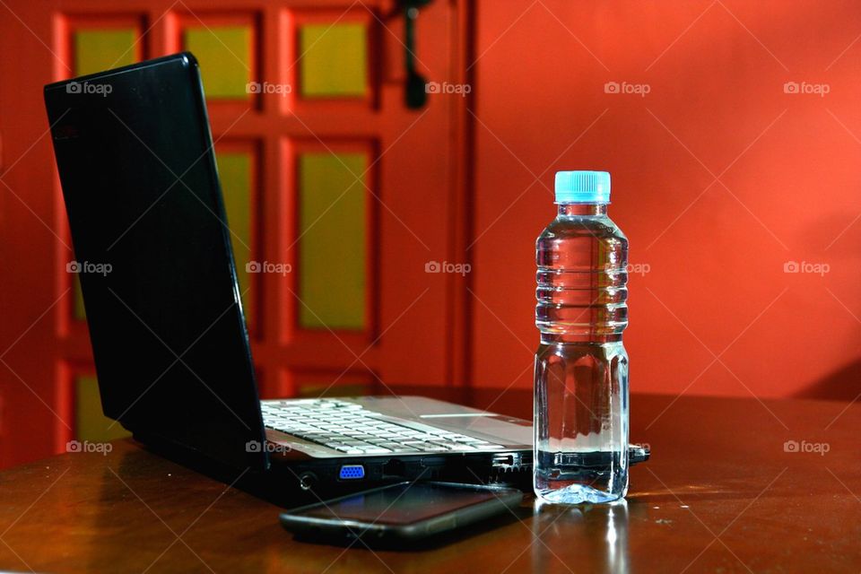 laptop computer, bottled water and smartphone