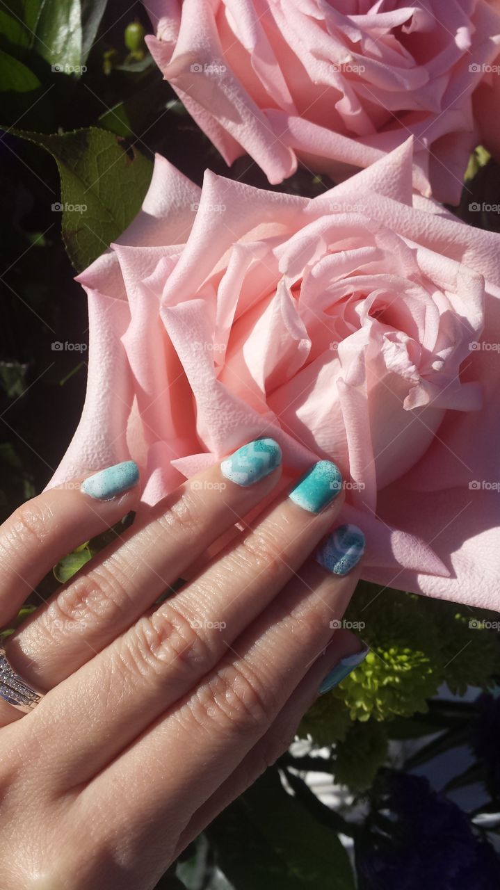 Teal nail art polish cute design, flowers in background, pink rose, flower arrangement