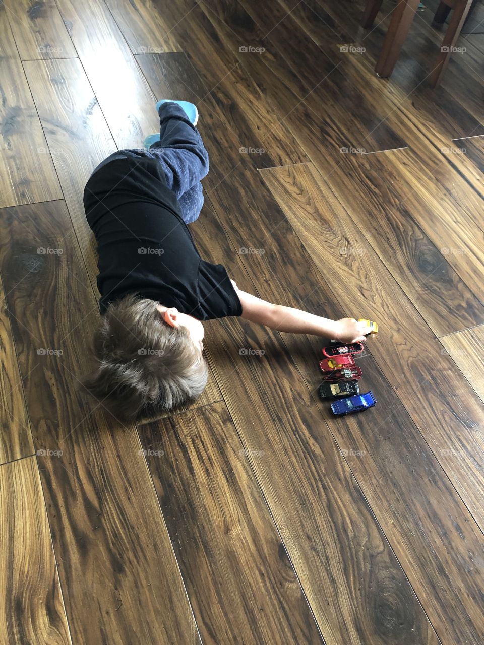 Toddler playing on floor with cars II