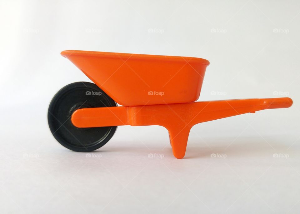 Orange wheelbarrow in white background