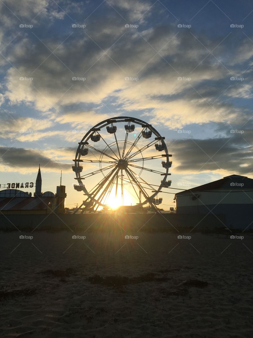 A beachside Ferris wheel sits above the pier. A reminder of the summer days as the sun sets behind the ride