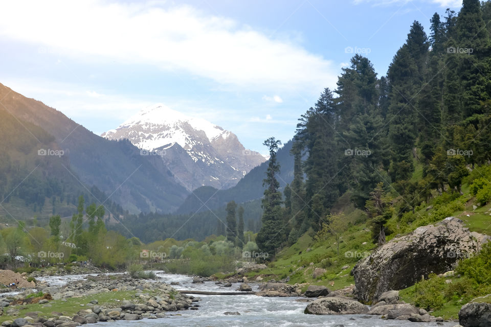 Majestic Jhelum River, a tributary of Indus River, passes through Kashmir Valley bounded by the Great Himalayas and Pir Panjal Range. Jammu and Kashmir, India. Nature Landscape background scenery.