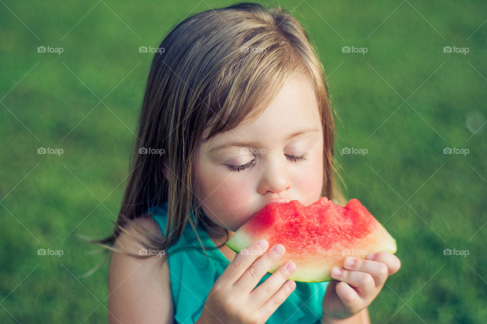 Young Girl Eating Watermelon Outside at Park 2