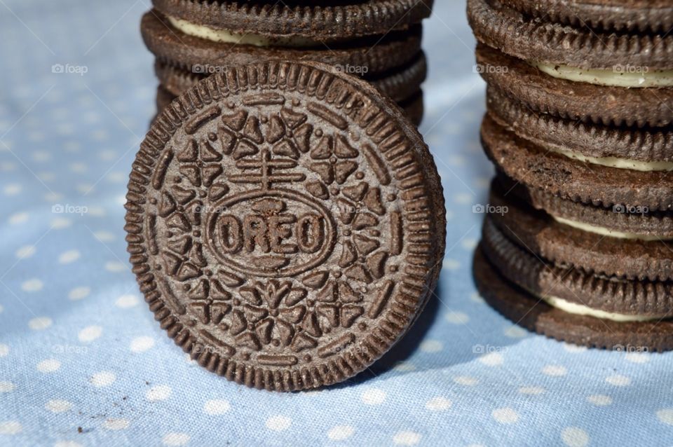A stack of Oreo cookies on a polkadot blue background