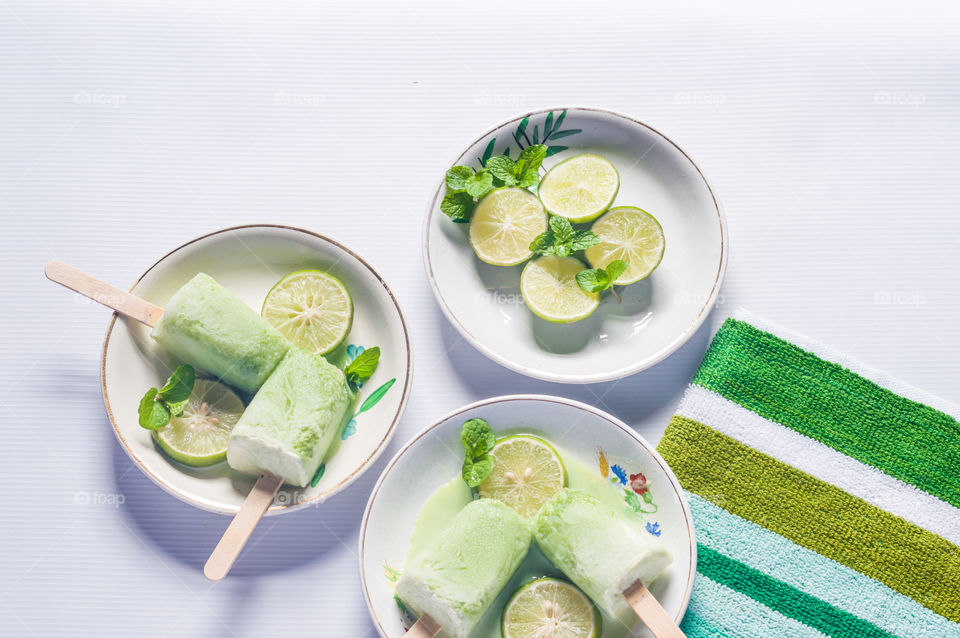 Mint popsicles in white plates isolated on white background.