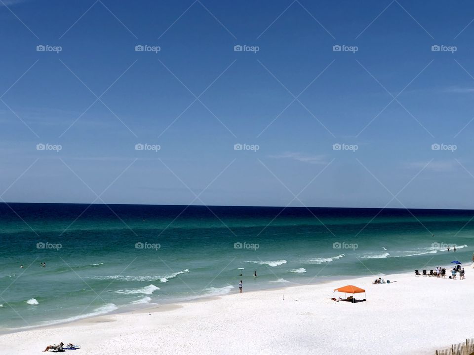 Clear blue sky with orange beach tent on sunny day 