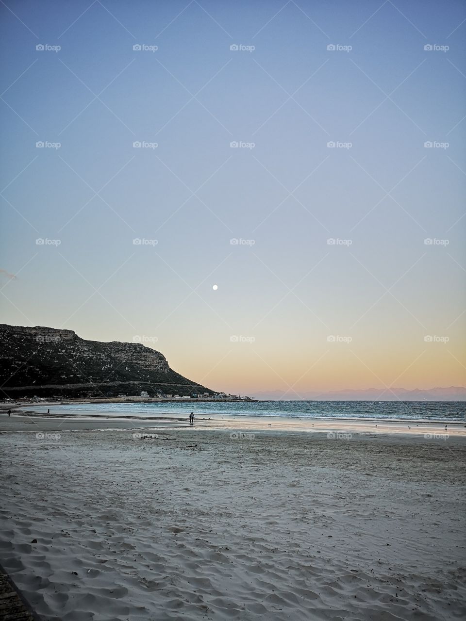 Moon shines at sunset at beach