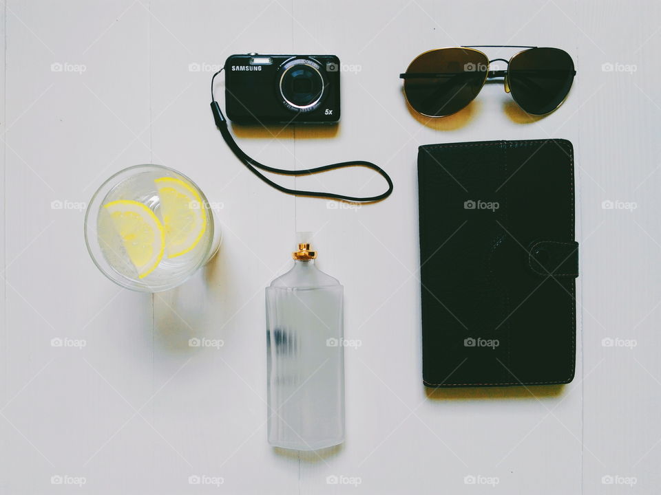 notebook, glasses, camera, toilet water and lemonade on a white background