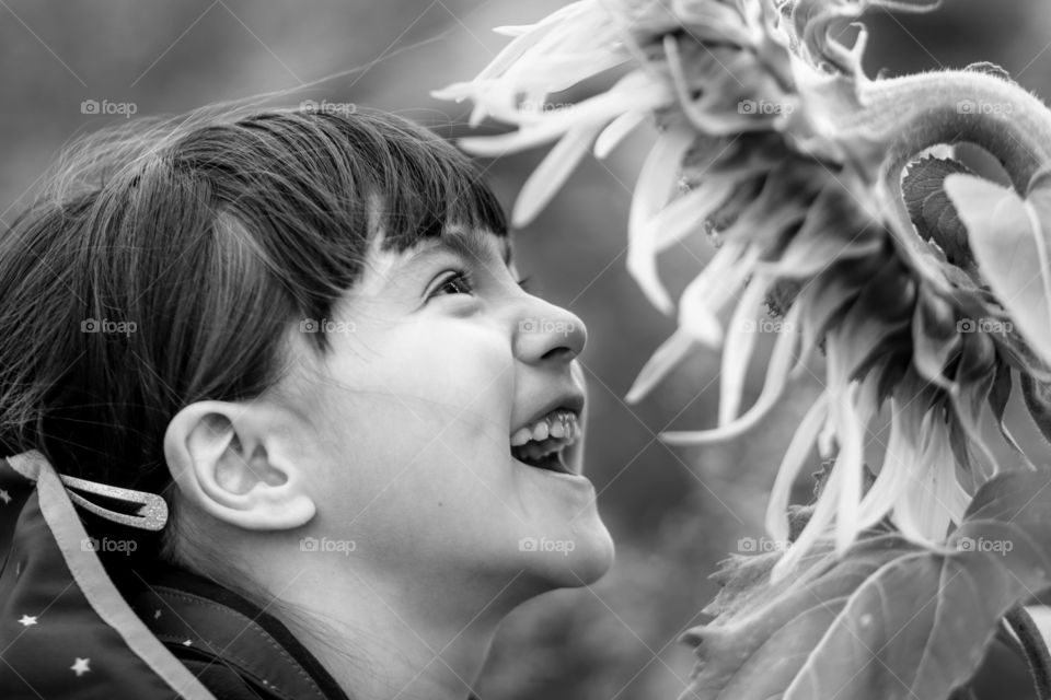 Happy little girl with a sunflower