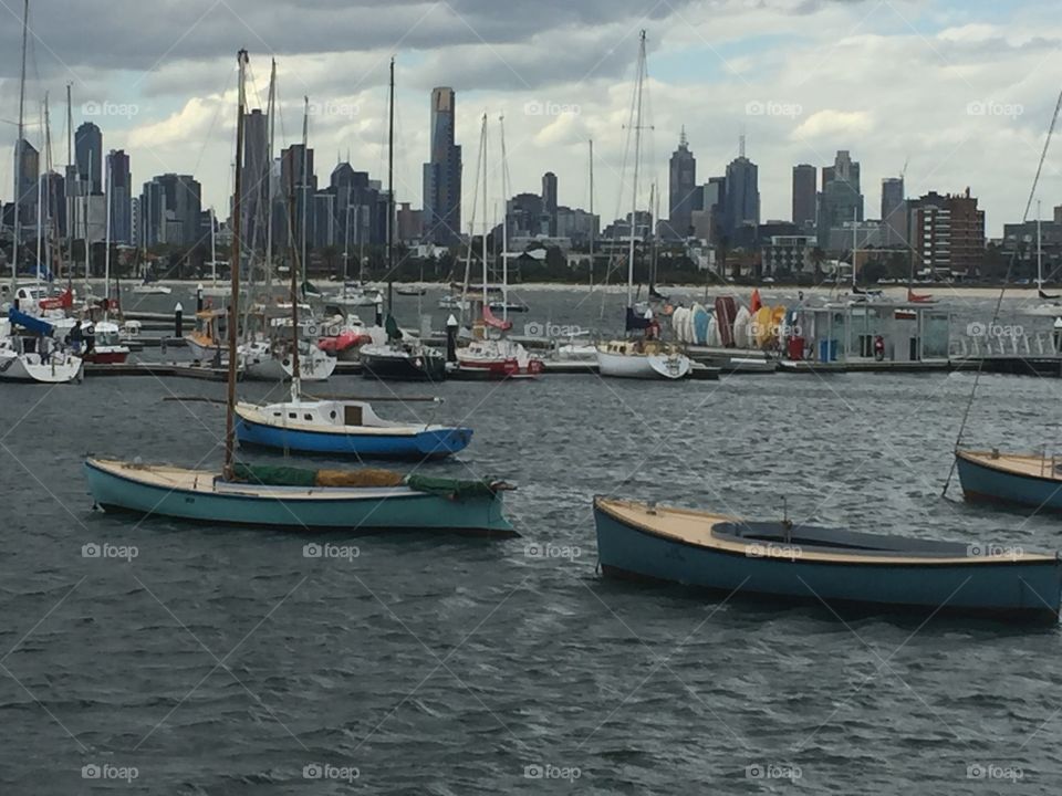Small boats set in front of  city skyline