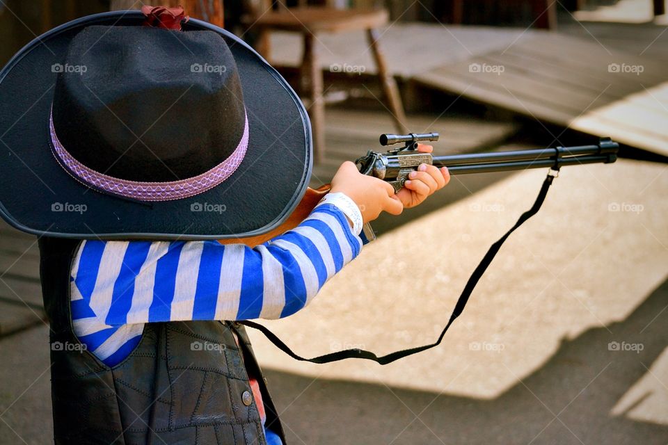 Boy playing. A boy is playing with his toy gun