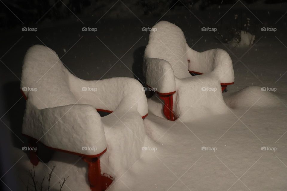 Lounge chairs covered with snow 