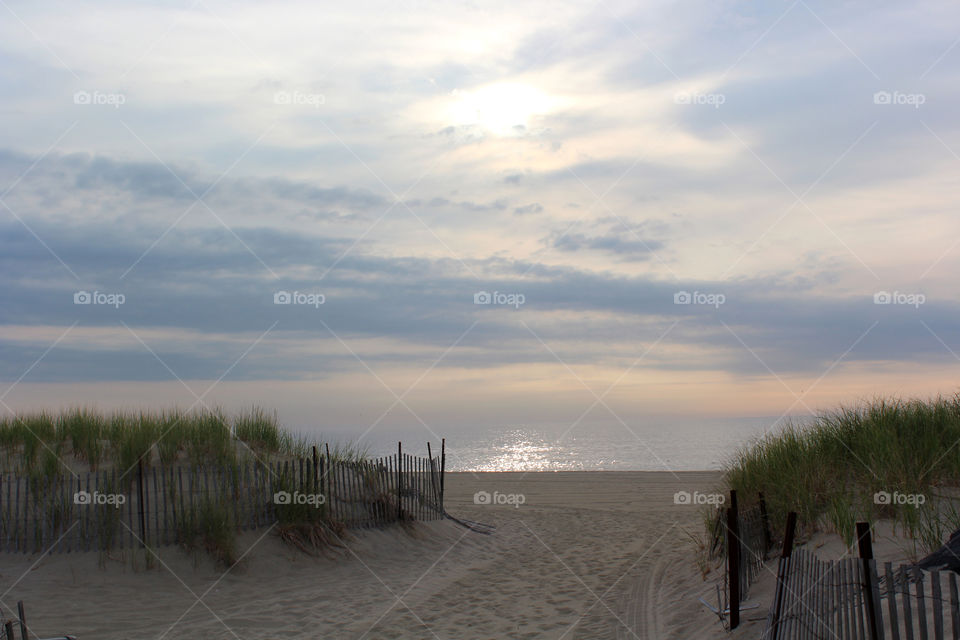 A beautiful ocean in New Jersey early in the morning and bikers are riding on the boardwalk. 