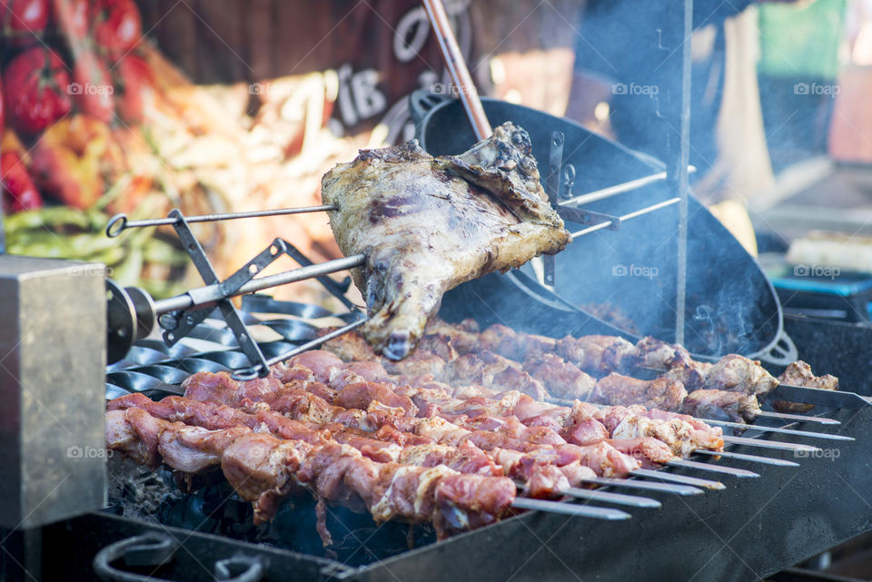 Barbecue fries in the coals. Meat and beef at the field kitchen festival. Delicious bbq kebab grilling on open grill