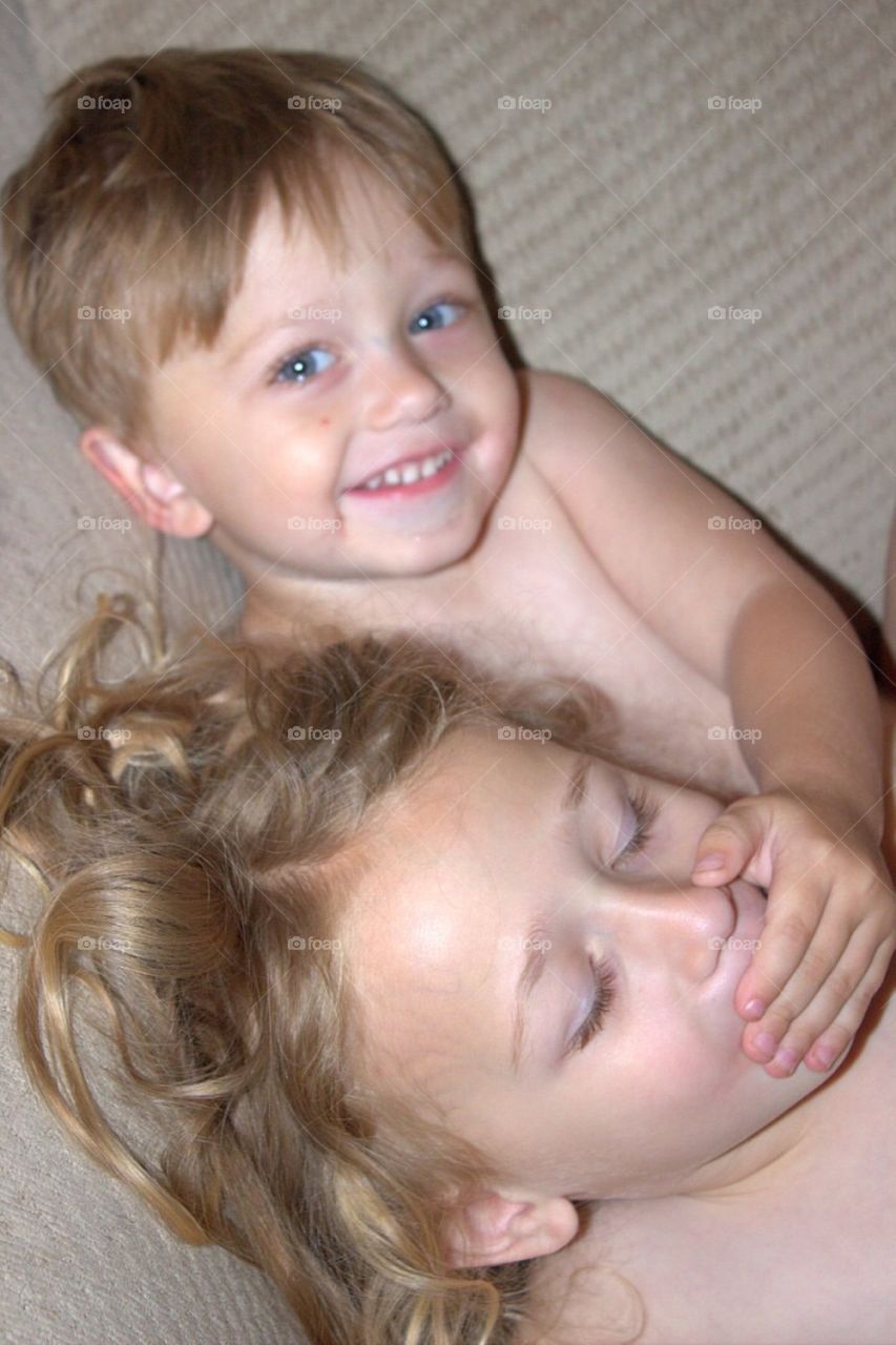 Little boy covering his sister's mouth