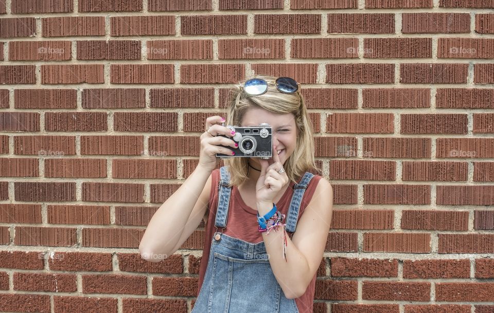 Beautiful young girl taking pictures with a vintage film camera