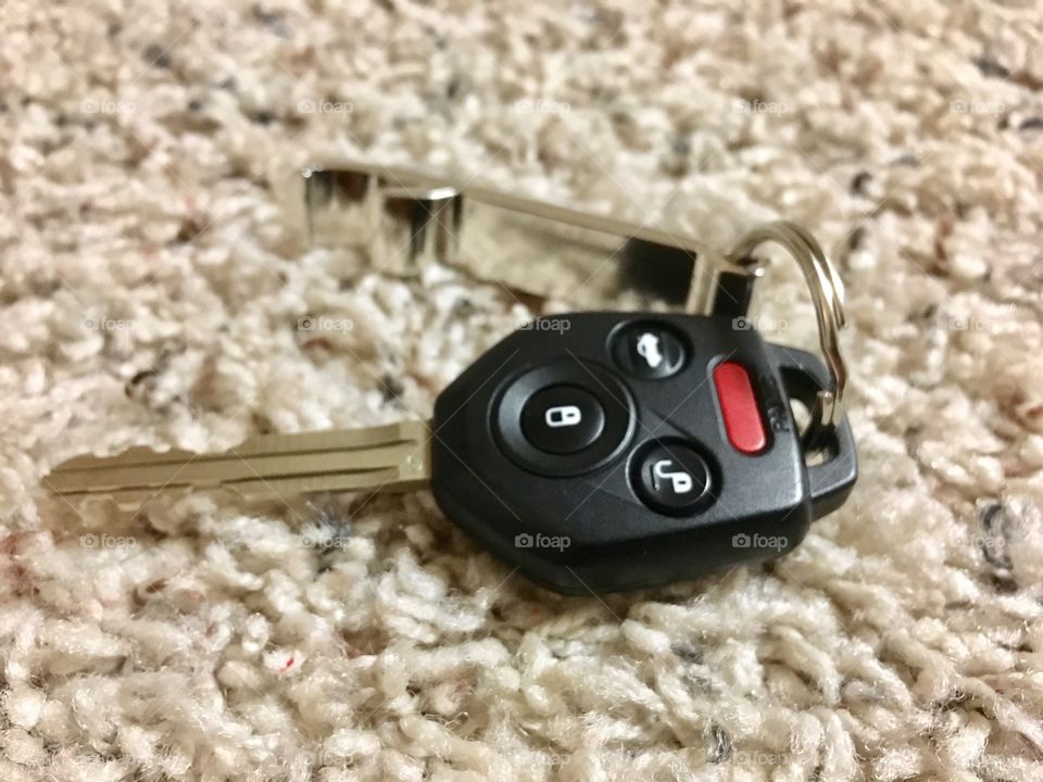 Car keys and bottle opener on carpet