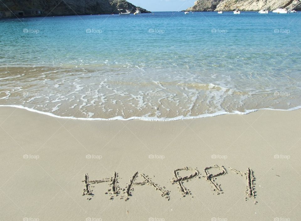 The word Happy in the sand. The word Happy written in the sand in Cala Vadella, Ibiza - Spain