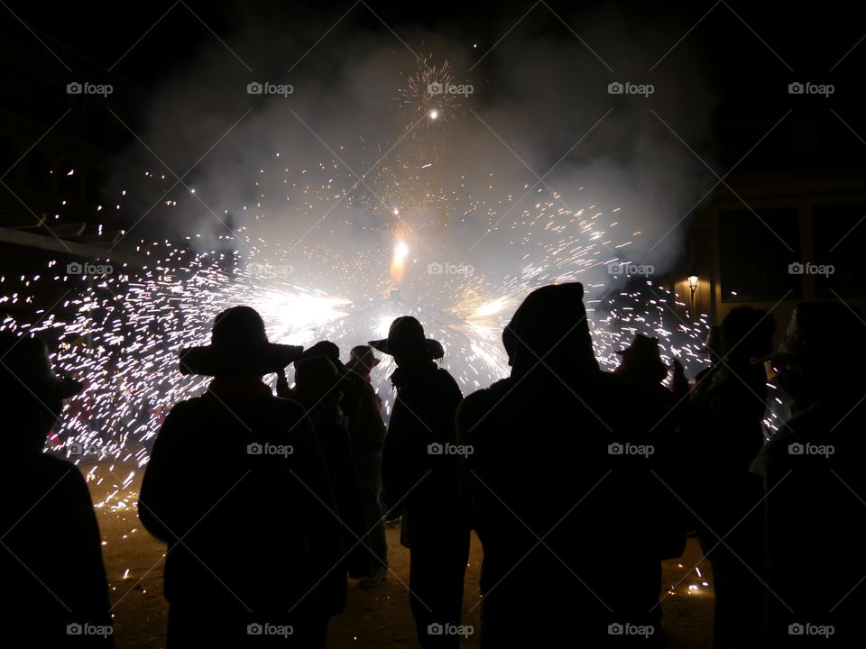 Silhouette of people looking at firework