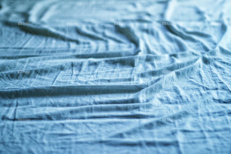 Full frame shot of a blue tattered bed sheet