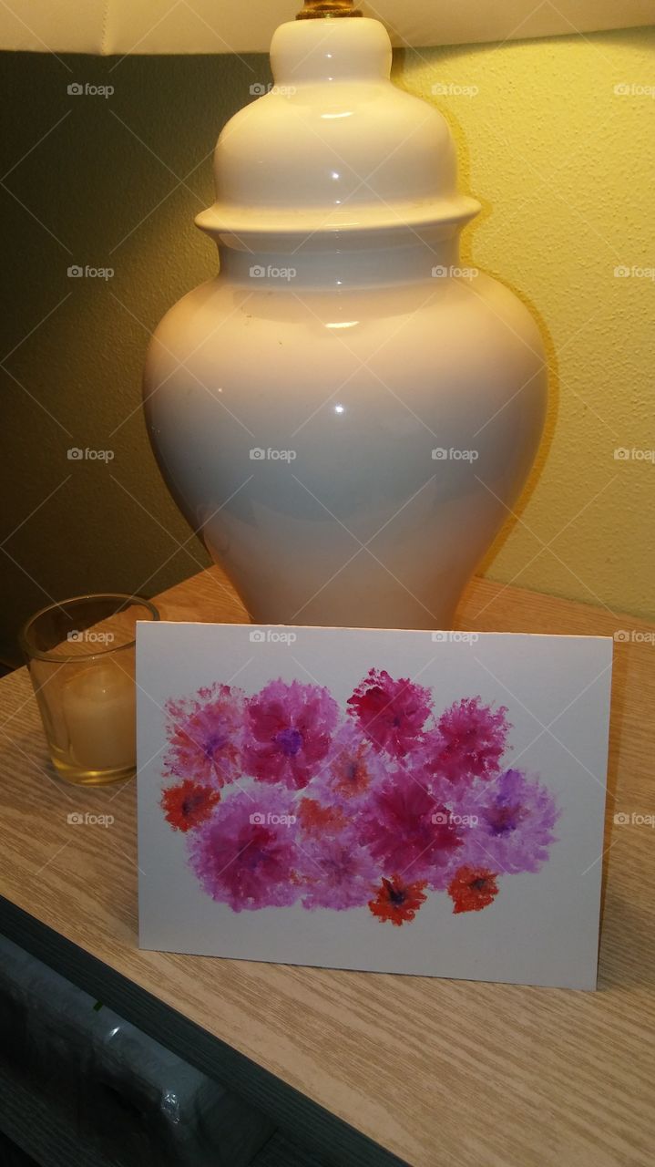 A lamp with a handmade card and candle.
