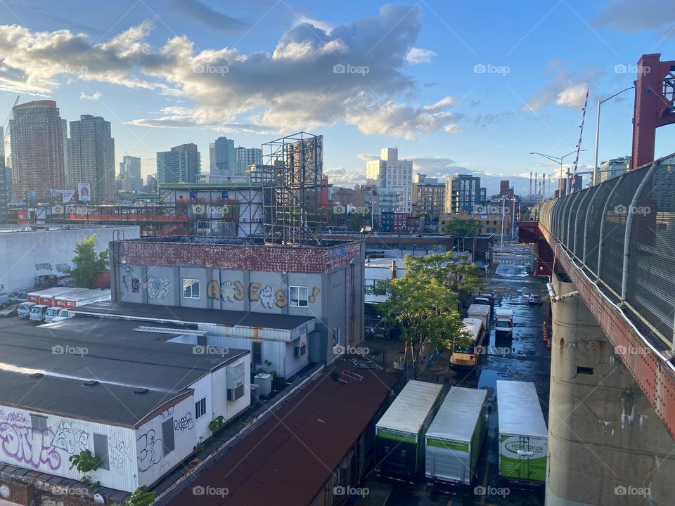 This is a view of “Long Island City” and further back of “Manhattan” as seen from the “Pulaski Bridge” at “Newtown Creek” in the warm soft light of the evening sun during the golden hour. 2023. Hypnotic Productions
