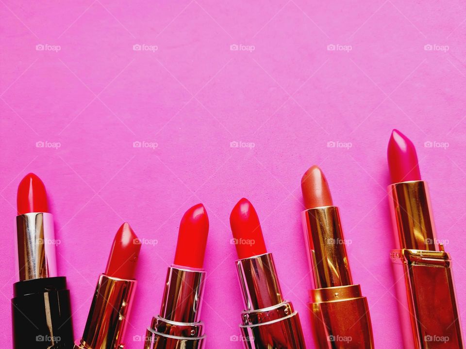 detail of colorful lipsticks on pink background
