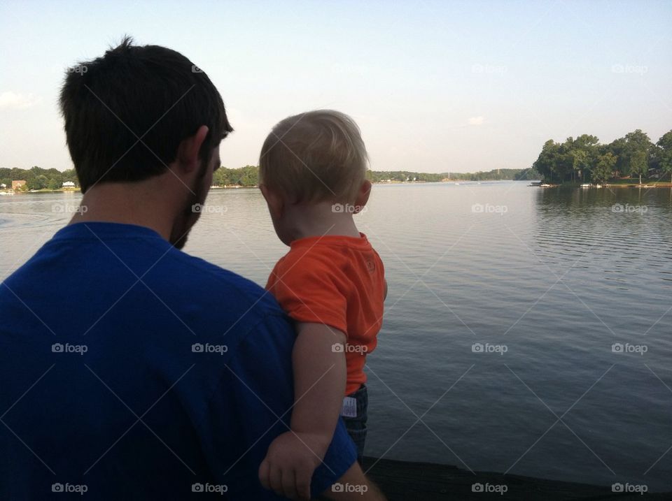 Father and son watching ducks from the dock