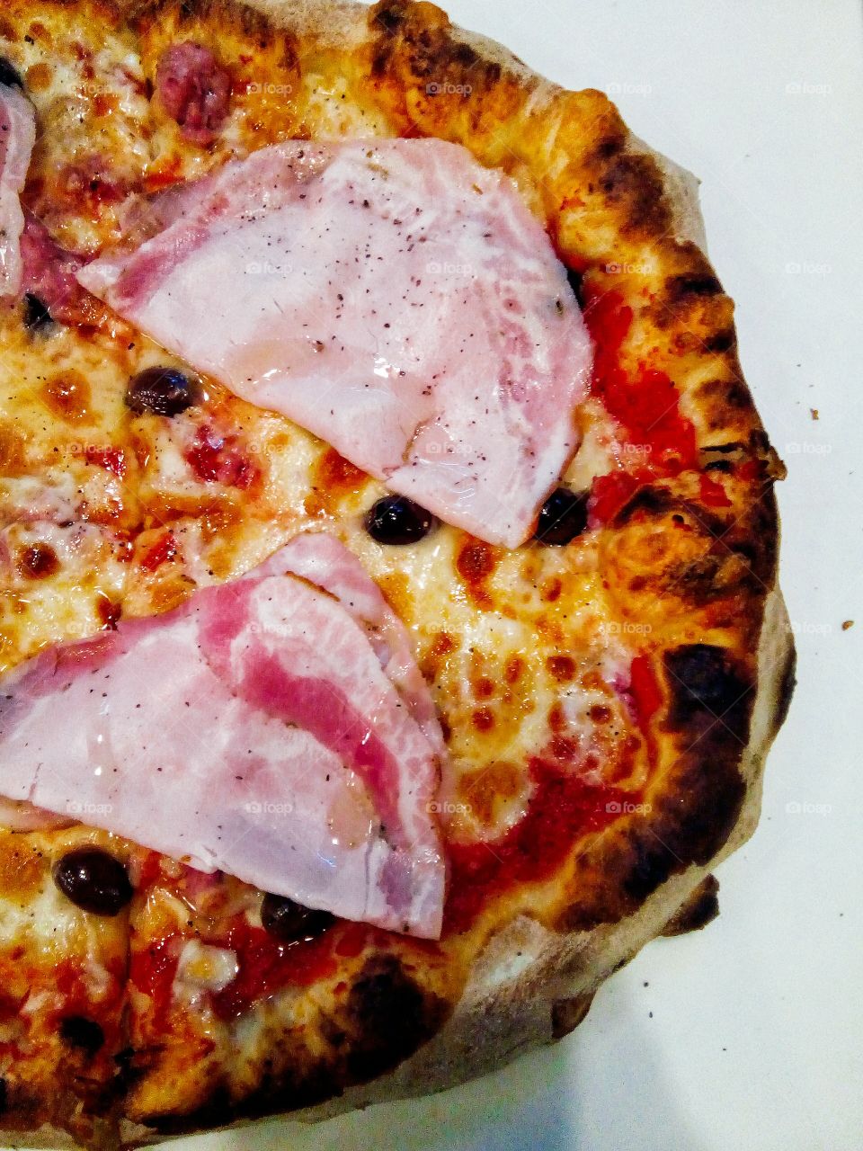 Italian pizza porchetta, scamorza e olive nere.