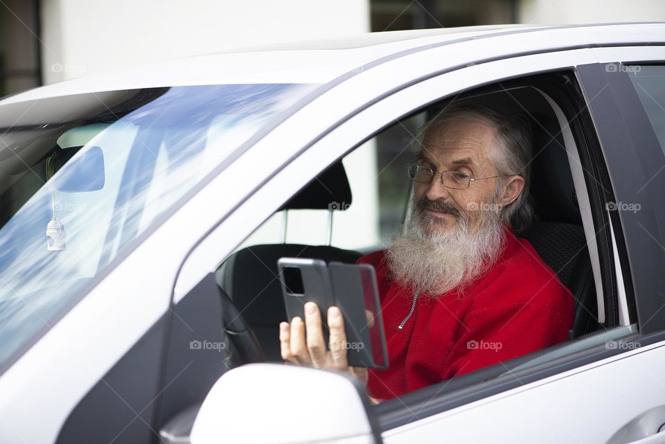 Senior man using phone in car