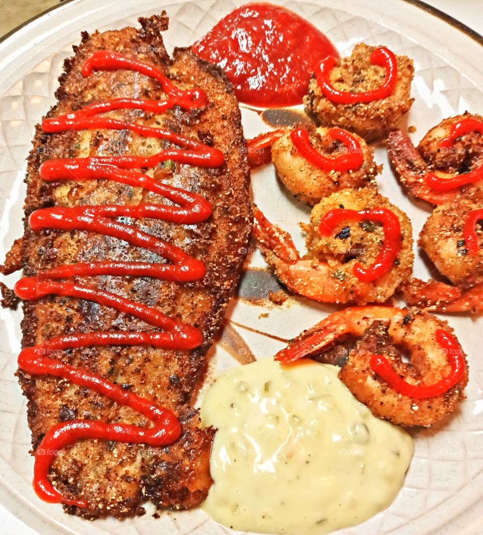 homemade fish, jumbo shrimp, tartar sauce, sriracha sauce and fish cocktail sauce