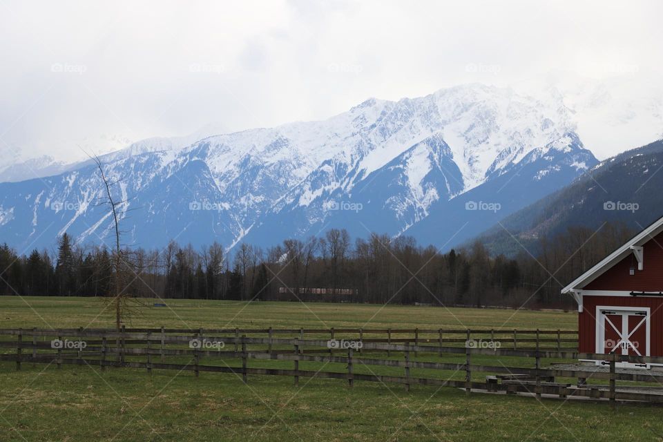 Canadian countryside- cottage in the valley and high mountains around 