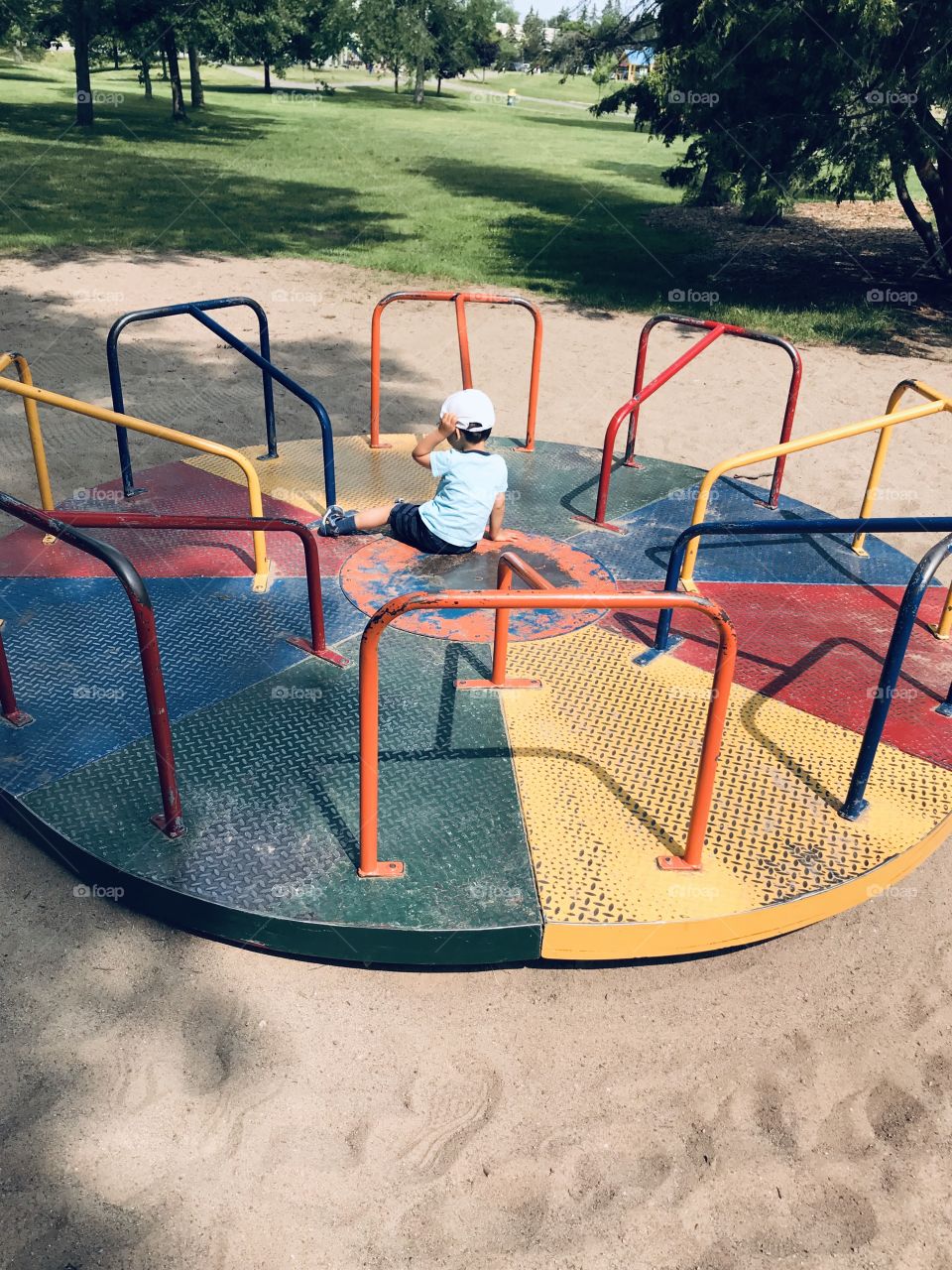 Little child on a roundabout in the park