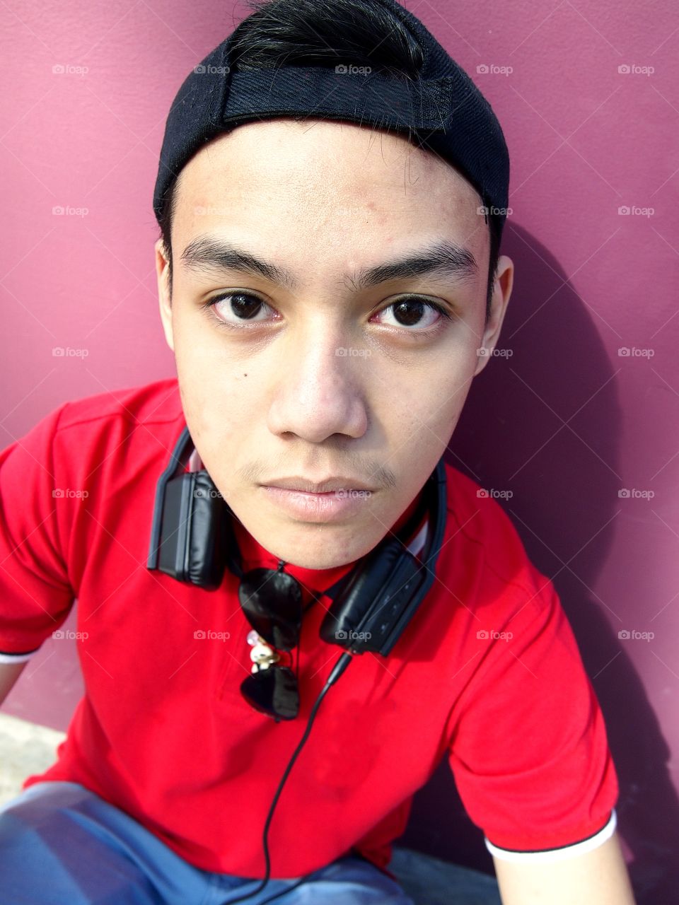 young teenage boy with cap, backpack, sunglasses and earphones