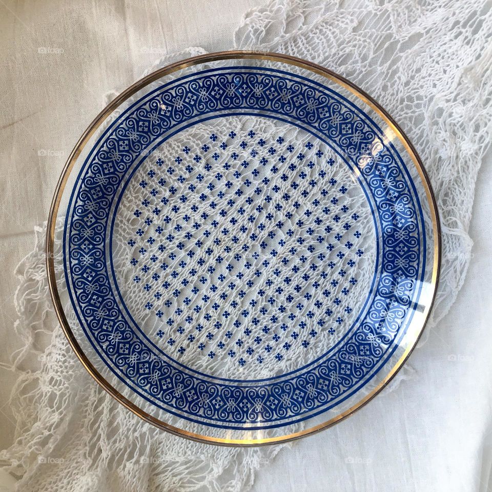 Transparent vintage plate with blue geometric ornament and gilding on the lace