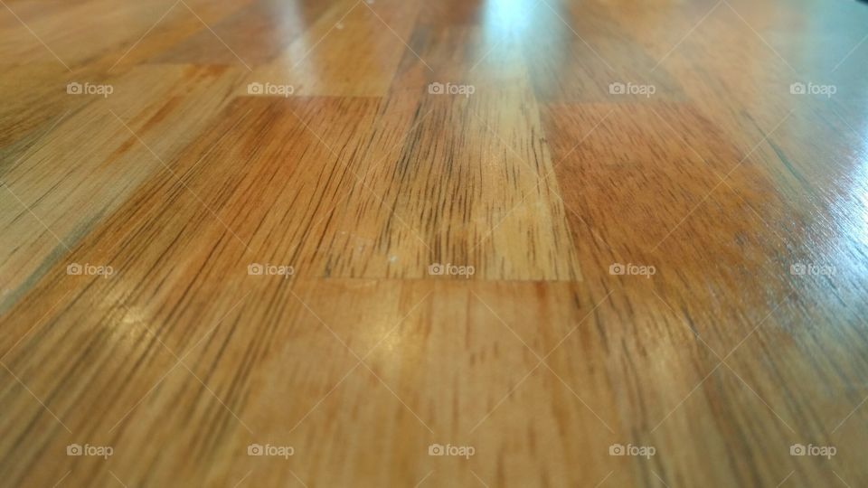 It looks like a wooden floor, or even a wooden-textured wall. But it is actually a table surface in a restaurant.