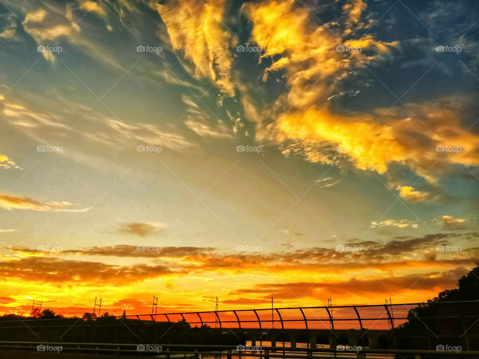 Yellow And Orange Sunset Clouds Over A Highway Bridge