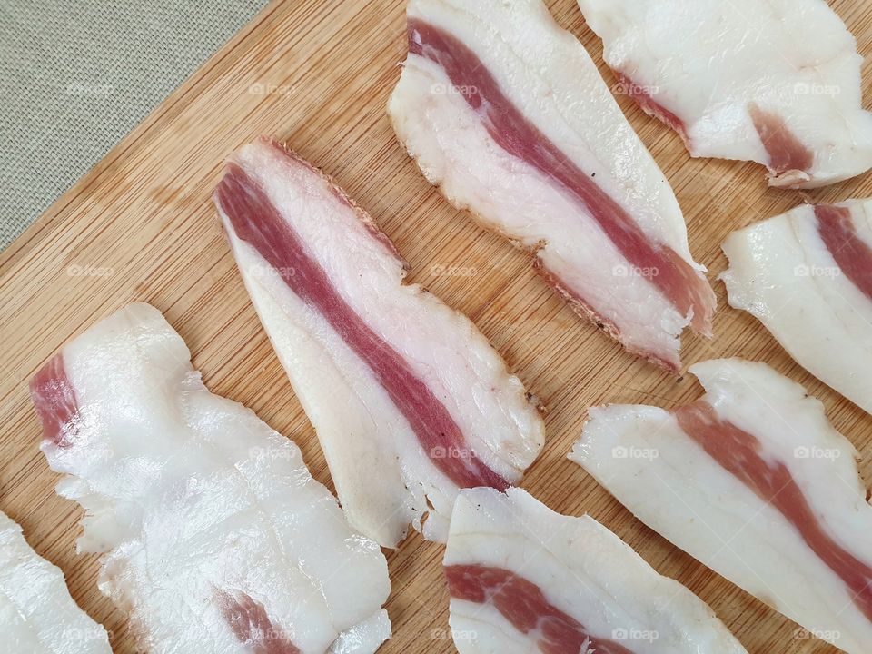 Sliced bacon on a wooden board