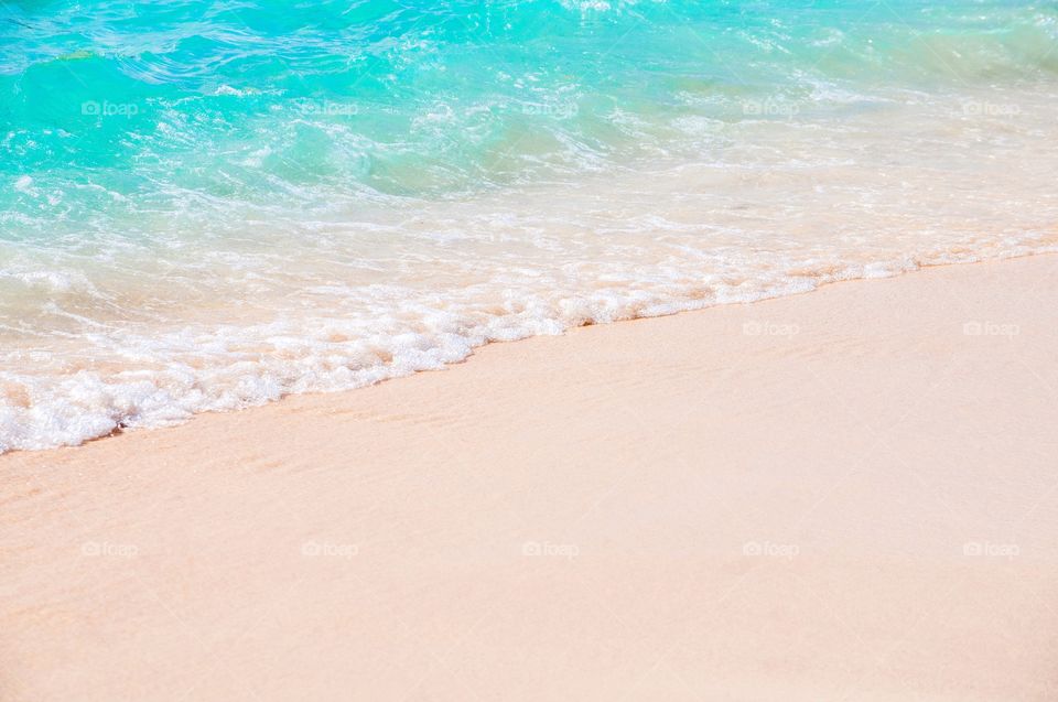 Clear beautiful waves roll over the white sand beach of Grand Turk. 