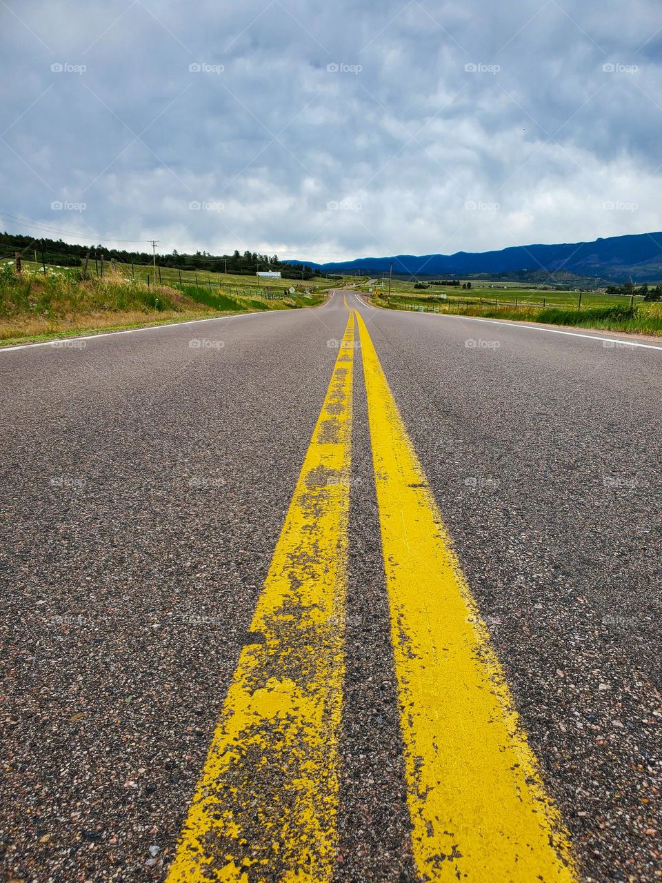 A long road cuts a ribbon through a remote country setting