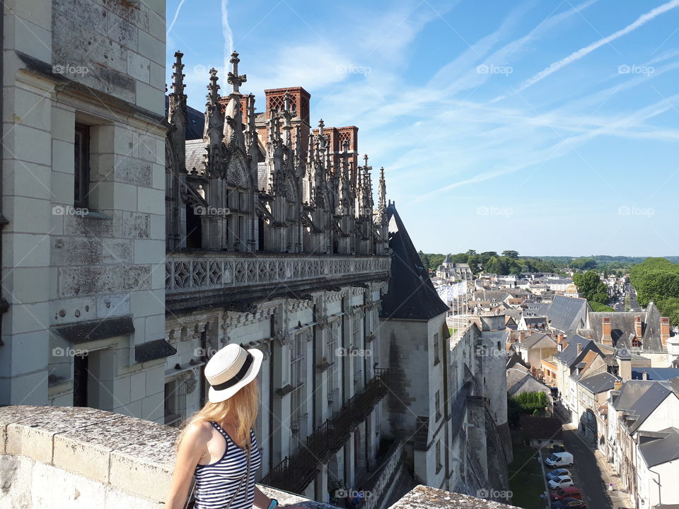 Woman looks at the city from the balcony of old castle