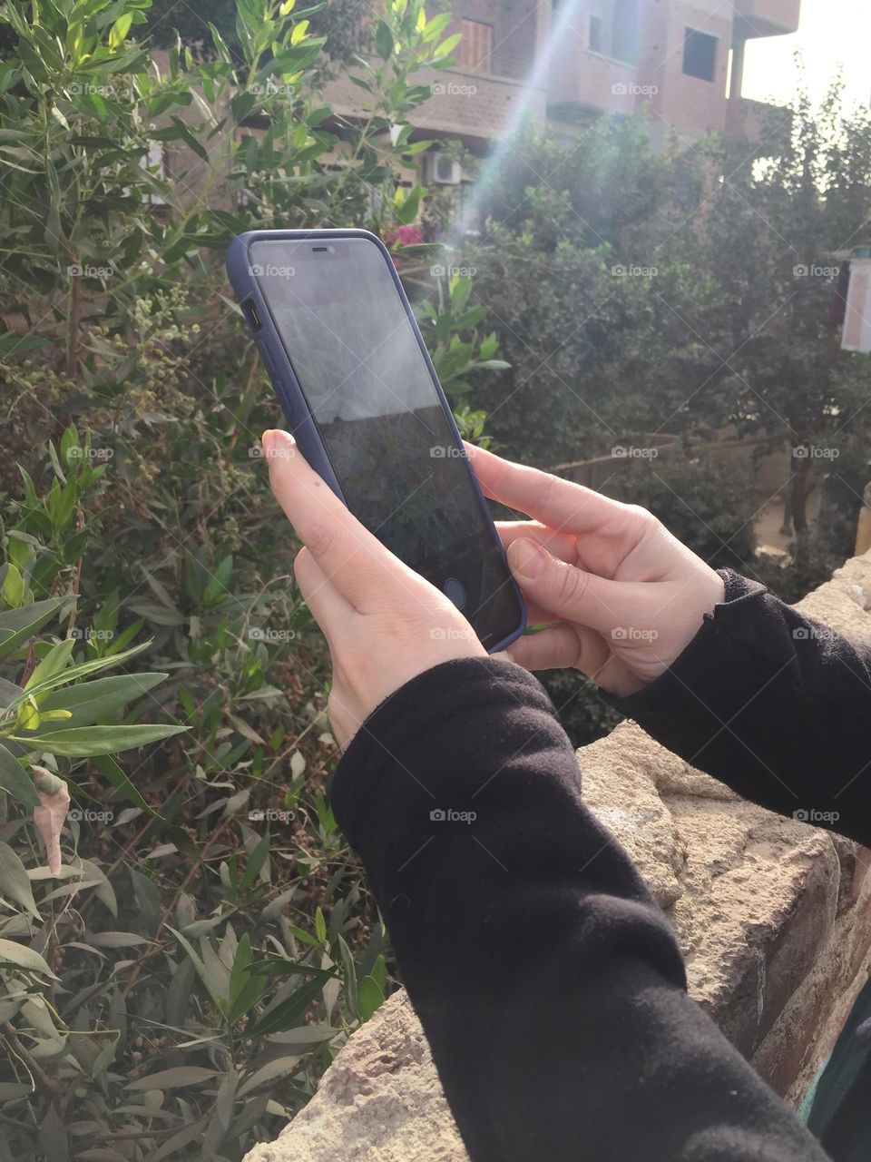 A young woman is taking a photo with her mobile phone 